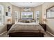 Bedroom with a large bed between two end tables, and bright windows that let in natural light at 6824 283Rd E St, Myakka City, FL 34251