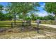 A gated entrance and long driveway approach a stately home set amidst mature trees at 6824 283Rd E St, Myakka City, FL 34251