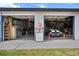 Spacious two-bay garage with vintage gas pump, custom shelving, and a black and white striped muscle car at 6824 283Rd E St, Myakka City, FL 34251