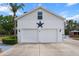 Exterior shot of white two-car garage with a star, set beneath blue skies at 6824 283Rd E St, Myakka City, FL 34251