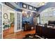 Well-lit home office with wood floors, modern desk, dark wood cabinet, and security safe for a focused work environment at 6824 283Rd E St, Myakka City, FL 34251