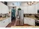 Spacious kitchen features stainless steel refrigerator and beautiful granite countertops and white cabinetry at 6824 283Rd E St, Myakka City, FL 34251