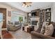Cozy living room features a brick fireplace, comfortable seating, and a ceiling fan at 6824 283Rd E St, Myakka City, FL 34251