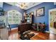 Home office featuring a rich wood desk, hardwood floors, and bold blue walls at 6824 283Rd E St, Myakka City, FL 34251
