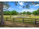 Scenic view of a white home with a pond and fencing in the foreground at 6824 283Rd E St, Myakka City, FL 34251