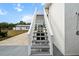 Stairway on the side of house leading up to an outdoor shower with a garage in the background at 6824 283Rd E St, Myakka City, FL 34251