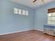 Bright, blue bedroom with hardwood floors, a ceiling fan, and windows offering natural light at 770 Yale St, Englewood, FL 34223