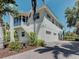 Two-story home featuring a two-car garage, palm trees, and lush landscaping at 770 Yale St, Englewood, FL 34223