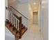Hallway with dark wood stairs and banister leading to upper level at 770 Yale St, Englewood, FL 34223