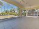 An empty screened-in porch with tiled floors and a view of the backyard and trees at 770 Yale St, Englewood, FL 34223