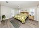Stylish bedroom with a leaf-patterned bedspread, wood-look floors and access to the outdoors at 791 Cumberland Rd, Venice, FL 34293