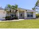 Charming home featuring tropical landscaping, a covered entryway, and an immaculate lawn at 791 Cumberland Rd, Venice, FL 34293