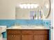 Bathroom with a double sink vanity with granite countertop and blue tiled backsplash at 810 Anchorage Ln, Palm Harbor, FL 34685
