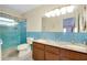 Bathroom with a double sink vanity, blue tile accents and a glass-enclosed shower at 810 Anchorage Ln, Palm Harbor, FL 34685
