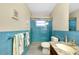 Bright bathroom featuring blue tile, updated sink and vanity, and a tiled glass shower at 810 Anchorage Ln, Palm Harbor, FL 34685