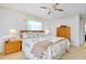 Comfortable bedroom with a ceiling fan, windows, and neutral-toned decor at 810 Anchorage Ln, Palm Harbor, FL 34685