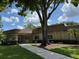 The clubhouse with its manicured lawn and inviting walkway under a beautiful tree, shows community at 810 Anchorage Ln, Palm Harbor, FL 34685