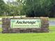 Stone sign for Anchorage, a deed restricted 55+ community with lush green lawns at 810 Anchorage Ln, Palm Harbor, FL 34685