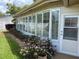 Bright enclosed patio with large windows and well maintained yard with vibrant pink flowers at 810 Anchorage Ln, Palm Harbor, FL 34685