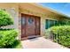 Charming stone facade, wooden door with wreath, and decorative anchor tiling at front entrance at 810 Anchorage Ln, Palm Harbor, FL 34685