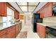 Efficient kitchen with matching cabinetry, black appliances, a stainless sink, and bright recessed lighting at 810 Anchorage Ln, Palm Harbor, FL 34685