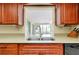 Kitchen with stainless sink and cherry cabinets and granite countertops at 810 Anchorage Ln, Palm Harbor, FL 34685