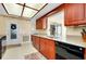 Well-maintained kitchen with cherry wood cabinetry, black appliances, stone countertops and tile flooring at 810 Anchorage Ln, Palm Harbor, FL 34685