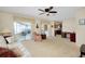 Bright living room with glass sliders, neutral carpet and an adjoining kitchen at 810 Anchorage Ln, Palm Harbor, FL 34685