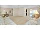Spacious living room featuring neutral walls, plush carpet, and an elegant chandelier at 810 Anchorage Ln, Palm Harbor, FL 34685