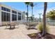 Outdoor patio seating area with tables, chairs, and landscaping overlooking the grounds and pool area at 8403 Placida Rd # 304, Placida, FL 33946