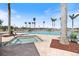 Beautiful swimming pool and spa area with lounge chairs and palm trees under a sunny, blue sky at 8403 Placida Rd # 304, Placida, FL 33946