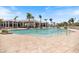 Stunning large community pool with an expansive pool deck and a covered clubhouse under a sunny sky at 8403 Placida Rd # 304, Placida, FL 33946