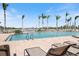 Relax in this resort-style pool with beautiful clear water, lounge seating, and lovely palm trees at 8403 Placida Rd # 304, Placida, FL 33946