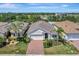 Beautiful aerial view of a well-maintained home featuring a manicured lawn and brick driveway at 8997 Excelsior Loop, Venice, FL 34293