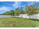 Expansive backyard features lush green grass and mature trees, perfect for outdoor activities and relaxation at 8997 Excelsior Loop, Venice, FL 34293