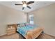 Comfortable bedroom with a ceiling fan, window, beach-themed bedding, and a wooden nightstand with decorative items at 8997 Excelsior Loop, Venice, FL 34293