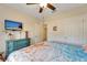Cozy bedroom features a ceiling fan, beach-themed bedding, stylish blue dresser with decorative accents, and doorway at 8997 Excelsior Loop, Venice, FL 34293