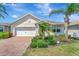 Charming single-story home with well-manicured lawn, mature palms, and a two-car garage at 8997 Excelsior Loop, Venice, FL 34293