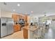 Kitchen featuring wood cabinets, stainless steel appliances, tile floors, and a breakfast bar with seating at 8997 Excelsior Loop, Venice, FL 34293