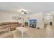 Inviting living room featuring tile floors, leather sectional, and a media center at 8997 Excelsior Loop, Venice, FL 34293