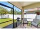 Relaxing screened porch with brick pavers, comfortable seating, and a view of the well-maintained backyard at 8997 Excelsior Loop, Venice, FL 34293