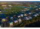 Expansive aerial view showcasing waterfront homes adjacent to a lush golf course with serene water features and manicured greenery at 9810 Eagle Preserve Dr, Englewood, FL 34224