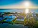 Picturesque view of a beautiful home surrounded by trees and situated near a tranquil body of water at sunset at 9810 Eagle Preserve Dr, Englewood, FL 34224