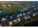Stunning aerial view of a beautiful golf community with an exquisite home, a waterway, and luscious trees at 9810 Eagle Preserve Dr, Englewood, FL 34224
