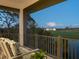 Relax on the balcony with comfortable seating and a serene view of the lush greenery and water at 9810 Eagle Preserve Dr, Englewood, FL 34224