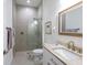 Modern bathroom with a glass-enclosed shower, neutral tile, and a vanity with a stone countertop at 9810 Eagle Preserve Dr, Englewood, FL 34224