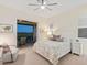 Bright bedroom with a ceiling fan, plantation shutters and access to a screened lanai overlooking the golf course at 9810 Eagle Preserve Dr, Englewood, FL 34224