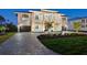 Magnificent two-story home displaying a lush green lawn, lovely landscaping, and a stone-paved driveway at 9810 Eagle Preserve Dr, Englewood, FL 34224