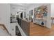 Elegant upper hallway with hardwood flooring, an art display, and natural light flooding through an open doorway at 9810 Eagle Preserve Dr, Englewood, FL 34224