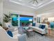 Spacious living room with plenty of seating and access to the outdoor balcony at 9810 Eagle Preserve Dr, Englewood, FL 34224